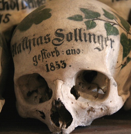 перед тем как отправить череп в костницу расписывает его цветочным орнаментом листьями крестиками пишет имя и выводит дату рождения и смерти.